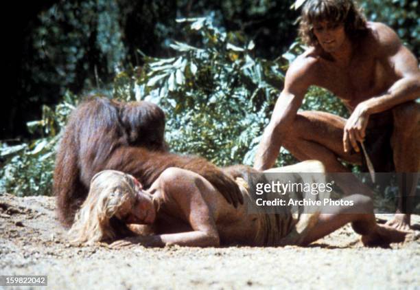 An ape has his arms on Bo Derek as she lays in the sand in a scene from the film 'Tarzan The Ape Man', 1981.