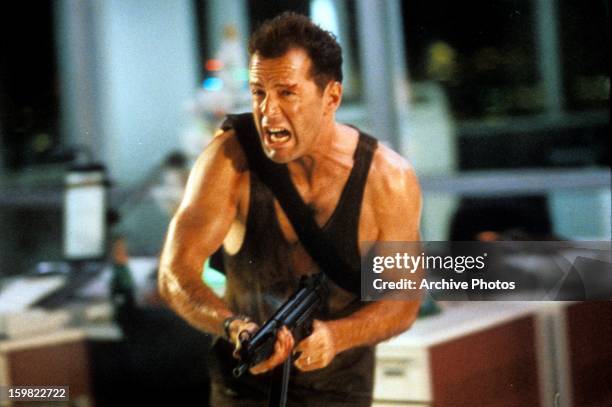 Bruce Willis running with automatic weapon in a scene from the film 'Die Hard', 1988.