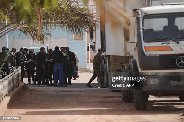 Algerian security and forensic officers monitor as body bags of victims that were killed during the hostage crisis at a desert gas plant in Algeria's...