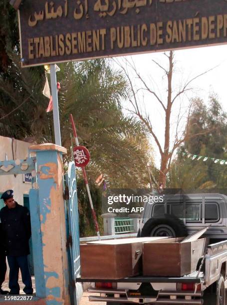 Algerian security personnel monitor as empty coffins are transported to collect victims that were killed during the hostage crisis at a desert gas...