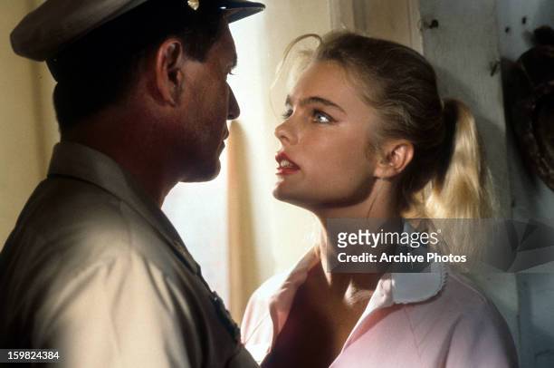 Tom Berenger and Erika Eleniak looking into each other's eyes in a scene from the film 'Chasers', 1994.