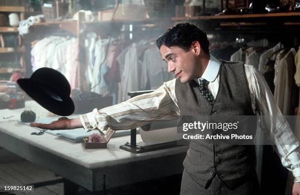 Robert Downey Jr playing around with his hat in a scene from the film 'Chaplin', 1992.