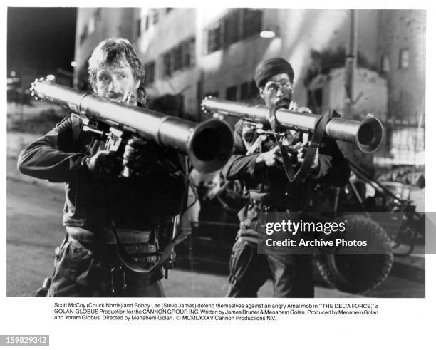 Chuck Norris and Steve James defend themselves against an angry Amal mob in a scene from the film 'The Delta Force', 1986.
