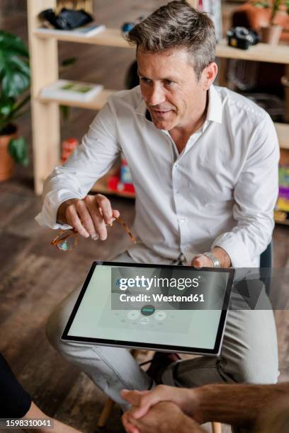 businessman explaining a mind map on tablet screen during a presentation in loft office - mind map stock pictures, royalty-free photos & images