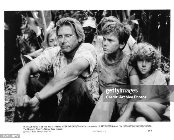 Harrison Ford and River Phoenix sitting in the jungle together in a scene from the film 'The Mosquito Coast', 1986.