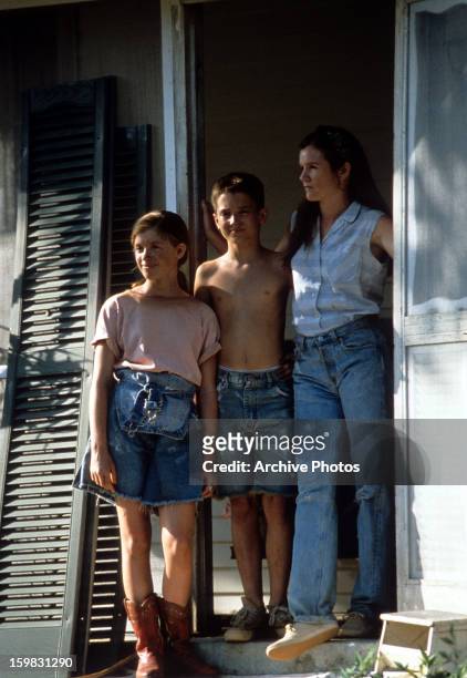 Lexi Randall, Elijah Wood and Mare Winningham stand in the doorway in a scene from the film 'The War', 1994.