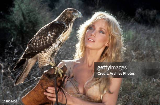 Tanya Roberts holding a perch with a bird on it in a scene from the film 'Sheena: Queen of the Jungle', 1984.