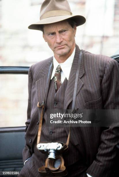 Sam Shepard with a camera hanging from his neck in a scene from the film 'Snow Falling On Cedars', 1999.