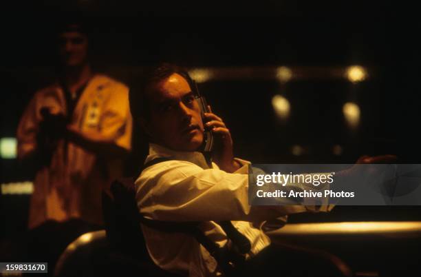 Powers Boothe holds a phone in a scene from the film 'Sudden Death', 1995.