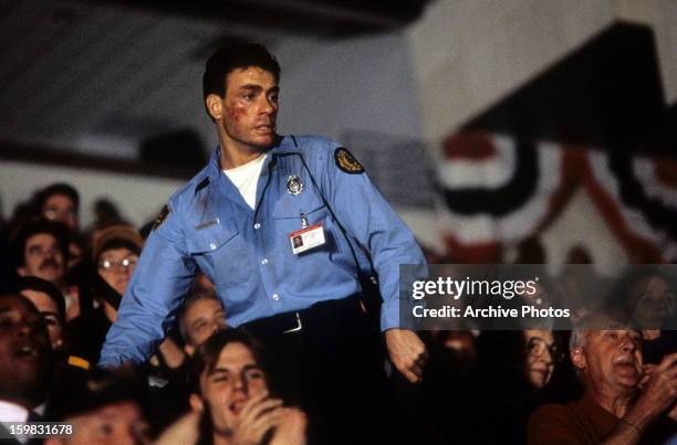 Jean Claude Van Damme stands over the crowd in a scene from the film 'Sudden Death', 1995.