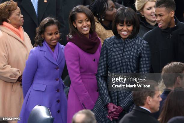 First lady Michelle Obama and daughters, Sasha Obama and Malia Obama arrive during the presidential inauguration on the West Front of the U.S....