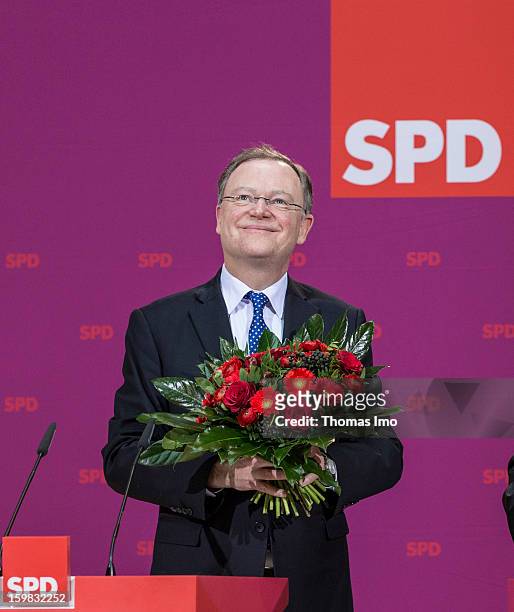 Stephan Weil, candidate in Lower Saxony for the German Social Democrats , holds a buquet of flowers during a press conference the day after the SPD...
