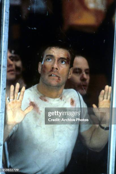 Jean Claude Van Damme puts his hands against glass in a scene from the film 'Sudden Death', 1995.