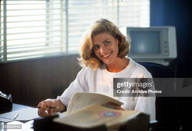 Kelly McGillis sits at a desk in a scene from the film 'Top Gun', 1986.