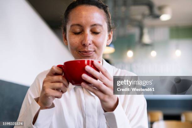 smiling businesswoman smelling fresh coffee at cafe - woman drinking stock pictures, royalty-free photos & images