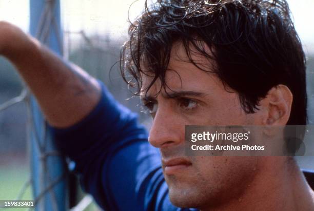 Sylvester Stallone looking through fence in a scene from the film 'Victory', 1981.