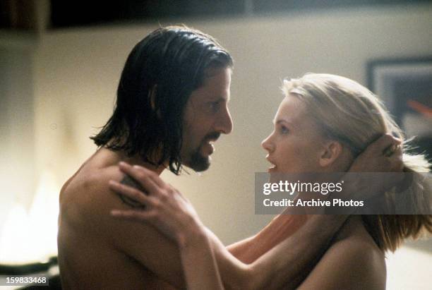 Anthony Guidera passionately holding onto Natasha Henstridge's head as she stares into his eyes in a scene from the film 'Species', 1995.