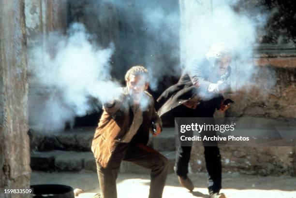 Paul Newman and Robert Redford firing guns in a scene from the film 'Butch Cassidy and the Sundance Kid', 1969.