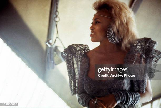 Tina Turner wearing silver attire in a scene from the film 'Mad Max Beyond Thunderdome', 1985.