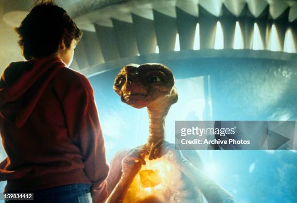 Henry Thomas talking with ET in a scene from the film 'E.T. The Extra-Terrestrial', 1982.