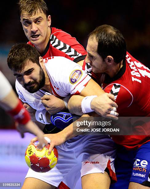 Spain's right back Jorge Maqueda vies with Serbia's left back Momir Ilic and Serbia's pivot Alem Toskic during the 23rd Men's Handball World...