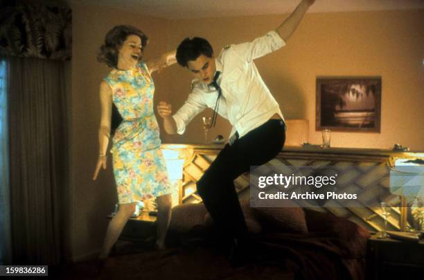 Leonardo DiCaprio dancing on top of a bed with a woman in a scene from the film 'Catch Me If You Can', 2002.