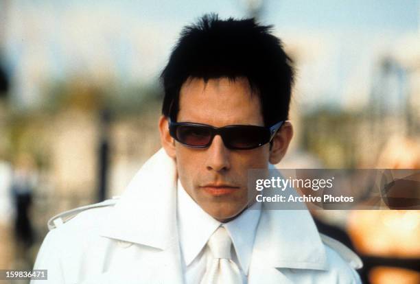 Ben Stiller dressed in an all white suit and wearing sunglasses in a scene from the film 'Zoolander', 2001.