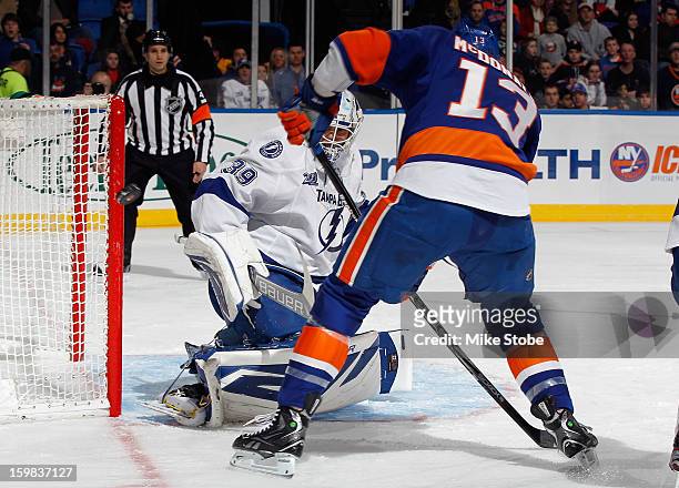 Goaltender Anders Lindback of the Tampa Bay Lightning defends the net as Colin McDonald of the New York Islanders looks for the rebound at Nassau...