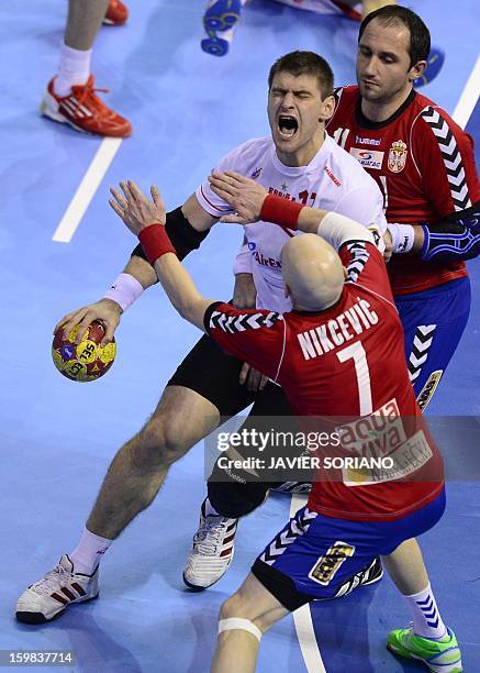 Spain's pivot Julen Aguinagalde vies with Serbia's left wing Ivan Nikcevic and Serbia's pivot Alem Toskic during the 23rd Men's Handball World...