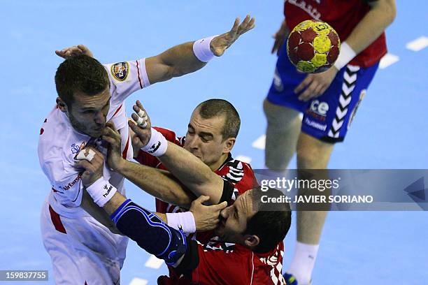 Spain's right wing Victor Tomas vies with Serbia's left back Milos Dragas and Serbia's pivot Alem Toskic during the 23rd Men's Handball World...