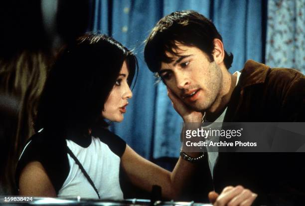 Shannen Doherty grabbing the cheek of Jason Lee in a scene from the film 'Mallrats', 1995.