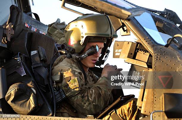 In this image released on January 21 Prince Harry wears his monocle gun sight as he sits in the front seat of his cockpit of an Apache helicopter at...