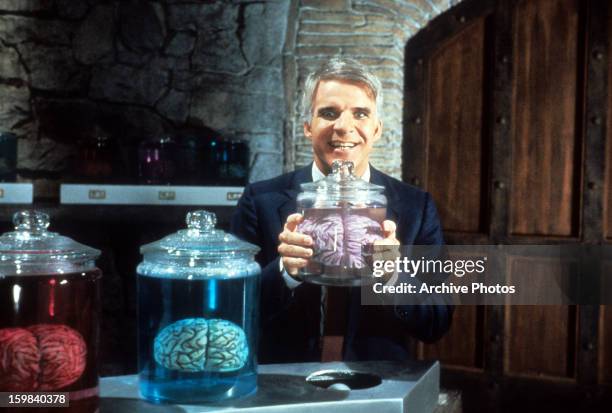 Steve Martin holding jar of brains in a scene from the film 'The Man With Two Brains', 1983.