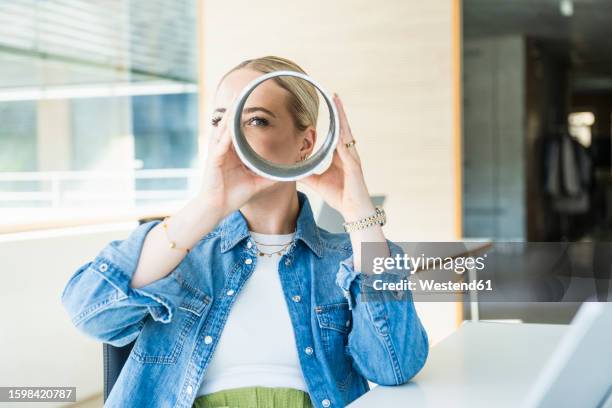 businesswoman looking through metallic circular equipment - see through stock pictures, royalty-free photos & images