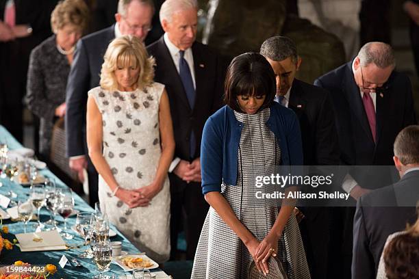 President Barack Obama, first lady Michelle Obama, Vice President Joe Biden and his wife Dr. Jill Biden, bow their heads during a prayer at the...