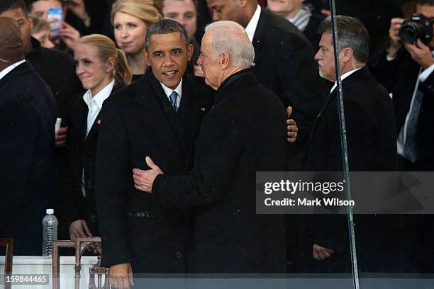 President Barack Obama talks with U.S. Vice President Joe Biden on the reviewing stand as the presidential inaugural parade winds through the...