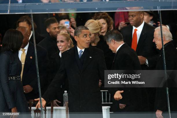 President Barack Obama reacts as he talks to U.S. Vice President Joe Biden as the presidential inaugural parade winds through the nation's capital...