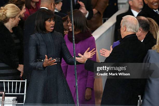 First lady Michelle Obama greets U.S. Vice President Joe Biden on the reviewing stand as the presidential inaugural parade winds through the nation's...