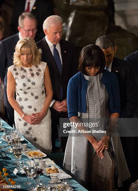 President Barack Obama, first lady Michelle Obama, Vice President Joe Biden, his wife Dr. Jill Biden, bow their heads during a prayer at the...