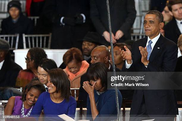 Sasha Obama, Malia Obama, First lady Michelle Obama, and U.S. President Barack Obama watch from the reviewing stand as the presidential inaugural...