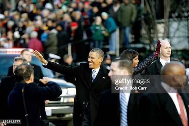 President Barack Obama and First lady Michelle Obama wave to onlookers as the presidential inaugural parade winds through the nation's capital...