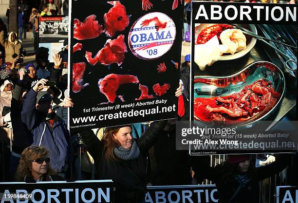 Anti-abortion activists hold signs during the inaugural parade on Pennsylvania Avenue January 21, 2013 in Washington, DC. Barack Obama was re-elected...