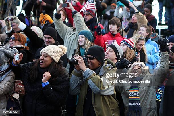 Spectators cheer as the presidential inaugural parade winds through the nation's capital January 21, 2013 in Washington, DC. Barack Obama was...
