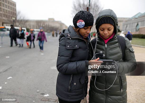 Ozzie of Philadelphia and Sophia of Washington DC listen to the Inauguration address by President Barack Obama on her iphone during the 57th United...