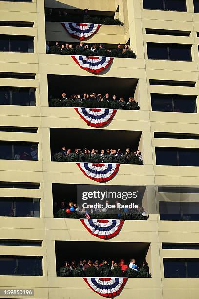 People watch as the inauguration parade passes by on January 21, 2013 in Washington, DC. President Barack Obama was ceremonially sworn in for a...