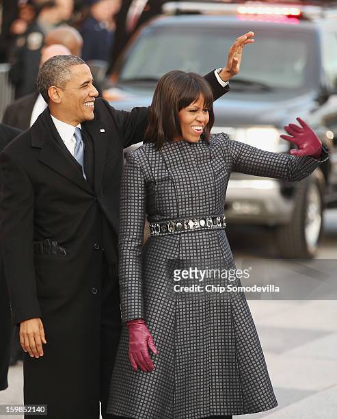 President Barack Obama and first lady Michelle Obama wave to supporters as they walk the inaugural parade route down Pennsylvania Avenue January 21,...