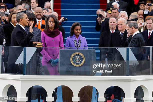 President Barack Obama is sworn in by Supreme Court Chief Justice John Roberts as first lady Michelle Obama , daughters Malia Obama and Sasha Obama...