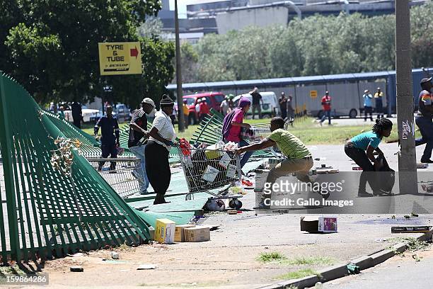 Protestors make a getaway with their loot on January 21 in Sasolburg, South Africa. Residents started to protest following the proposed incorporation...