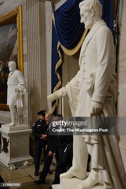 Statue of Abraham Lincoln towers over President Barack Obama and Vice President Joe Biden in the rotunda after the pair were sworn in at the...