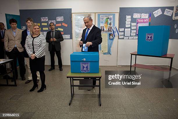 Israeli Prime Minister Benjamin Netanyahu casts his ballot watched by wife Sara Netanyahu and sons Yair Netanyahu and Avner Netanyahu at a polling...